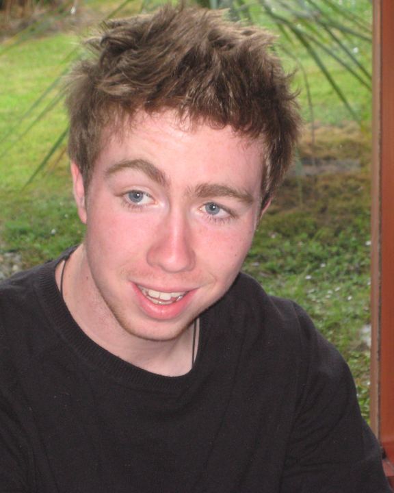A younger Ryan smiling at the camera